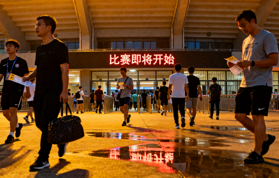 傍晚体育场馆外景，观众陆续入场准备观看比赛